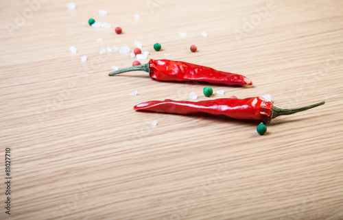 Red chili, sea salt and colorful bell pepper on a light wooden t