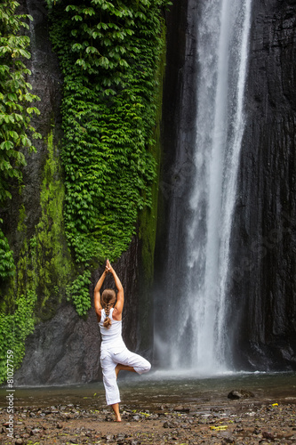 woman meditating doing yoga between waterfalls