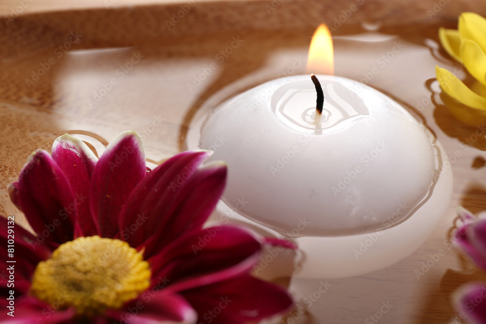 Bowl of spa water with flowers and candle, closeup Bowl of spa water with flowers and candle, closeup