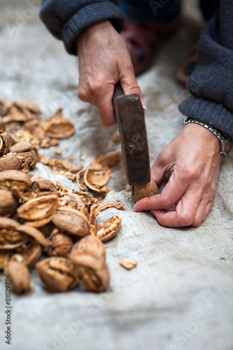 Woman crushing walnuts outdoor