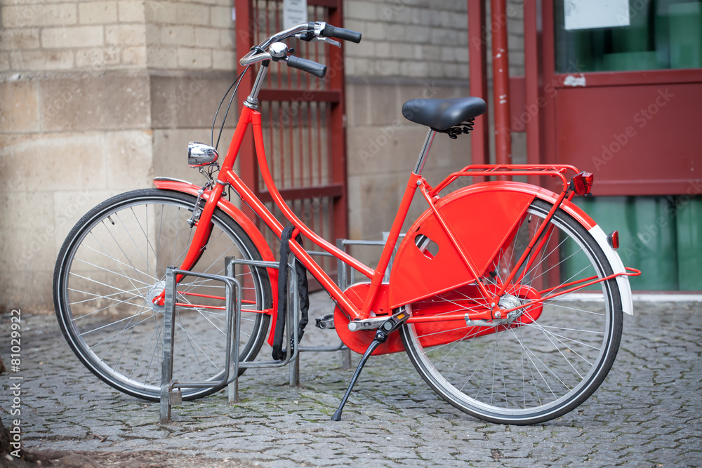 Red bicycle parked in the city