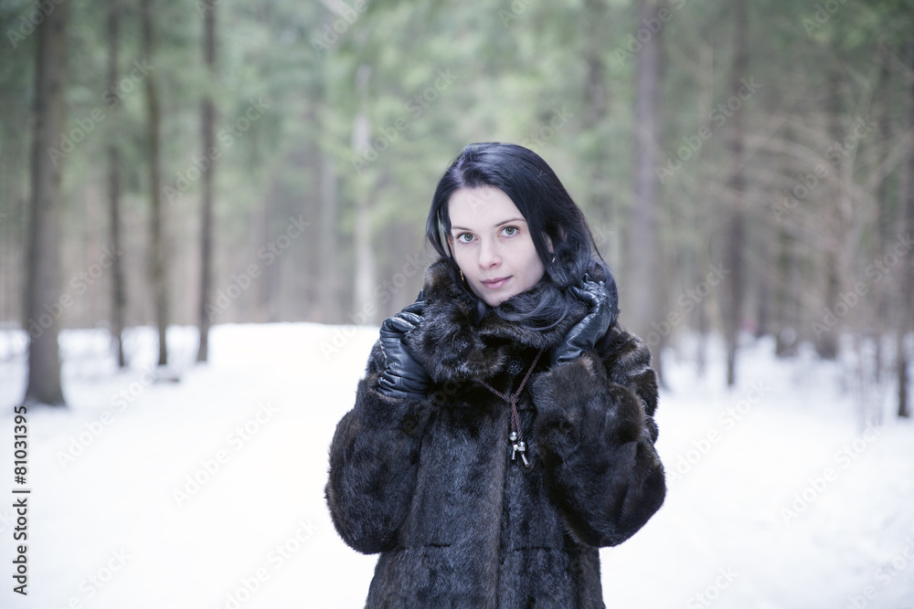 Girl wearing a fur coat in winter forest Girl wearing a fur coat in winter forest