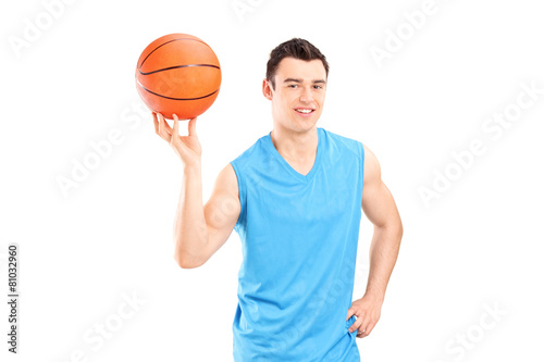 Young smiling basketball player in blue dress posing with a ball