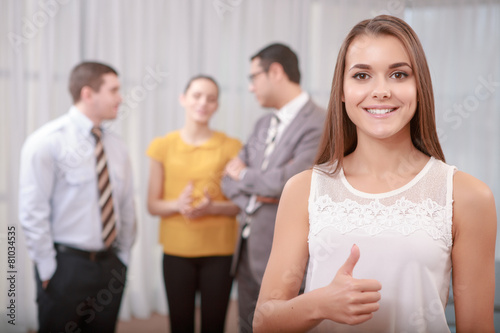 Young business woman shows thumbs up