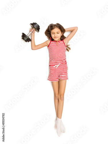 Isolated shot of little girl lifting heavy dumbbell