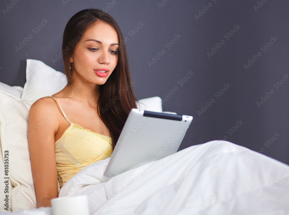 Women use a tablet pc on the bed Women use a tablet pc on the bed