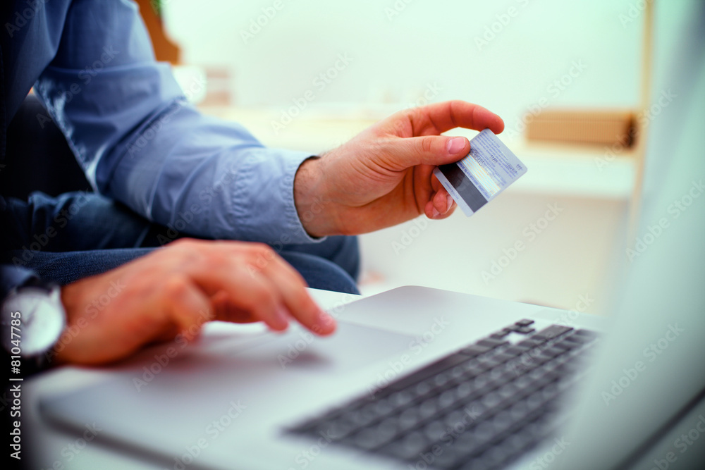 Businessman using his credit card for an online transaction