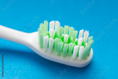 Toothbrush closeup on a blue background.