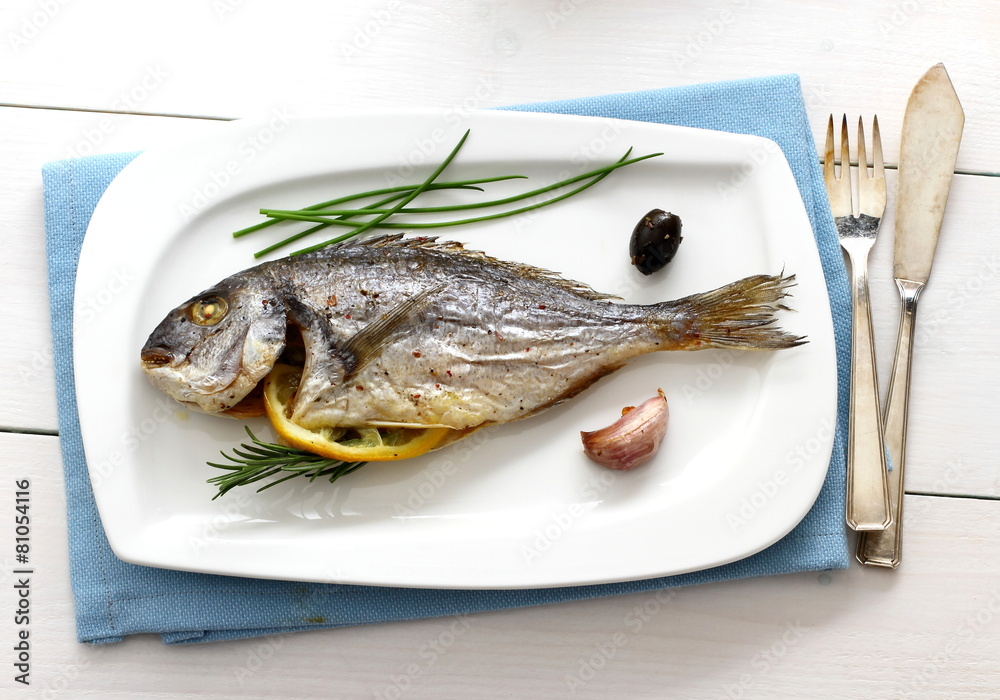 Garnished grilled whole sea bream with olives Garnished grilled whole sea bream with olives
