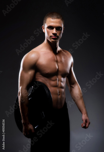 Strong, fit and sporty bodybuilder man in a studio