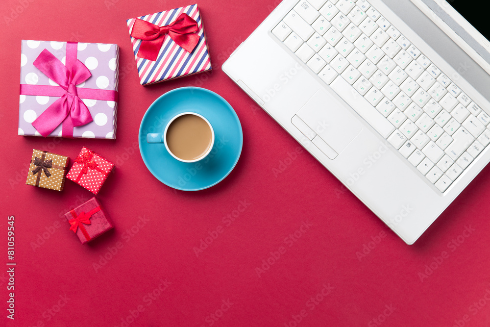 Cup of coffee and gift near computer Cup of coffee and gift near computer