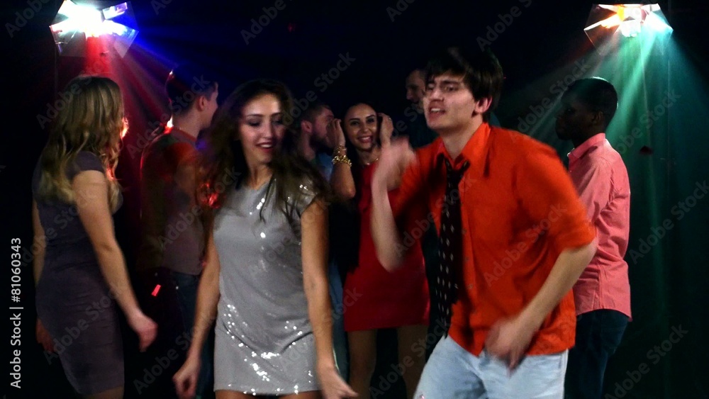 Pretty couple of young people dancing at a party in the