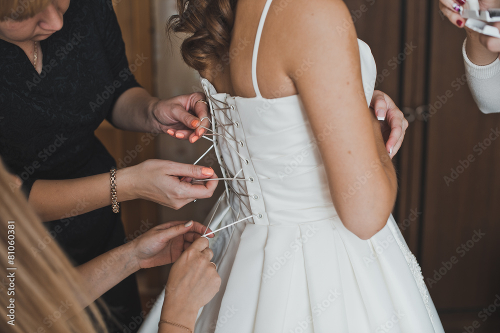 The girlfriend helps the bride to dress a wedding dress 2263.