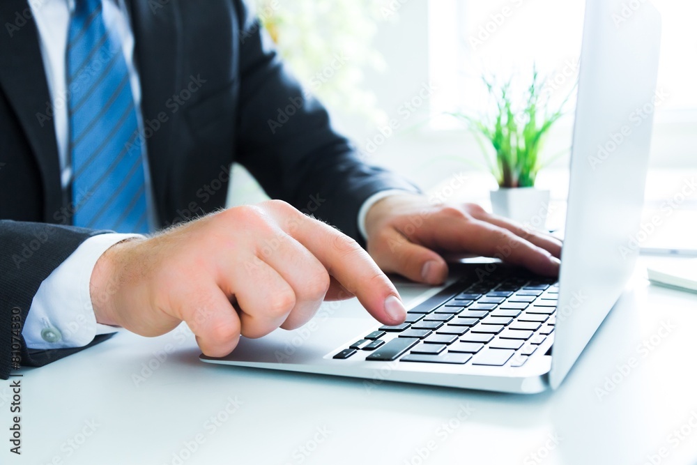 Laptop. Close up of business man hands typing on laptop computer Laptop. Close up of business man hands typing on laptop computer