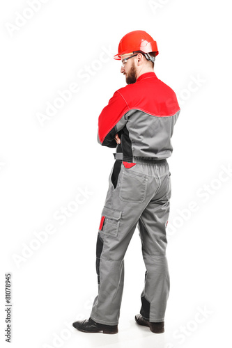 rear view of man wearing overalls with red helmet