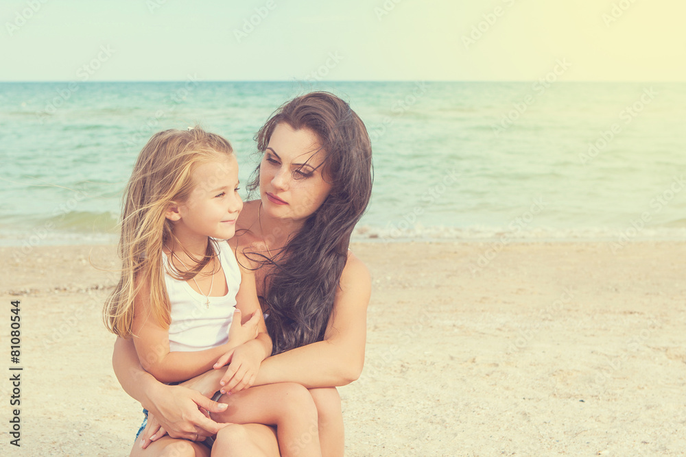 Mother and her daughter  having fun on the beach