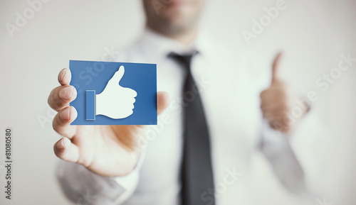 Like Card holded by hand and thumbs up photo