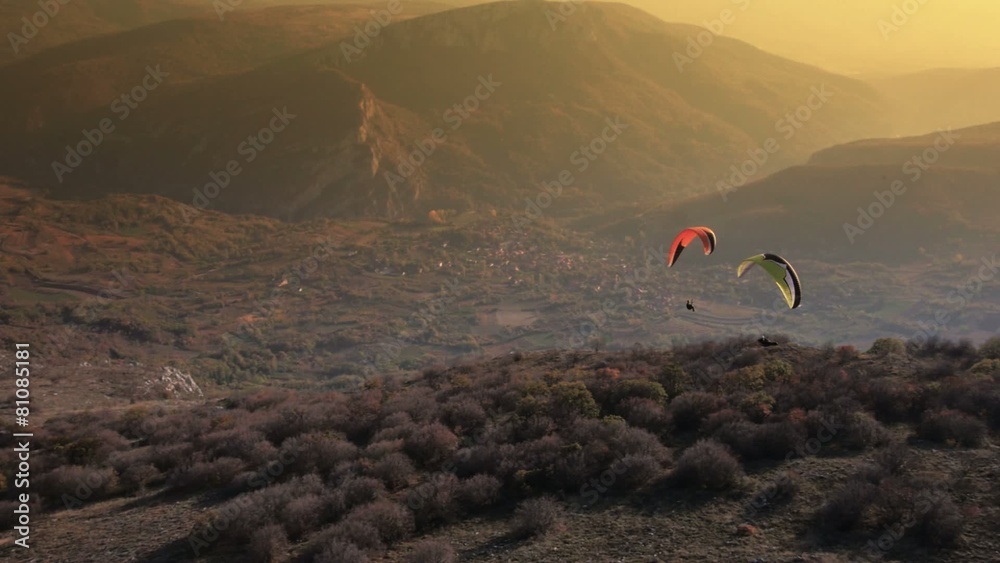 Paraglider Soaring Over The Mountains during sunset

