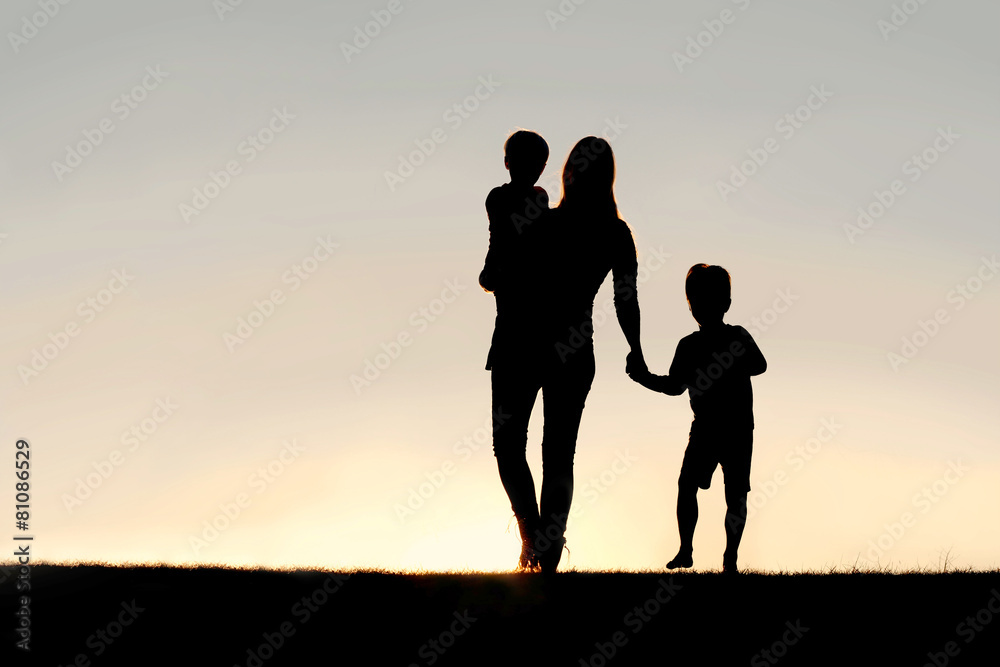 Silhouette of Walking Mother and Young Children Holding Hands at
