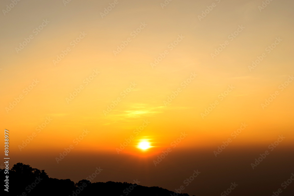 Rising sun with golden sky over mountain