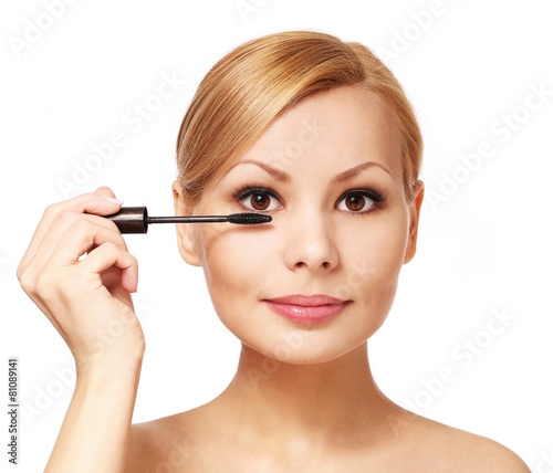 Beautiful woman applying mascara on her eyelashes, isolated