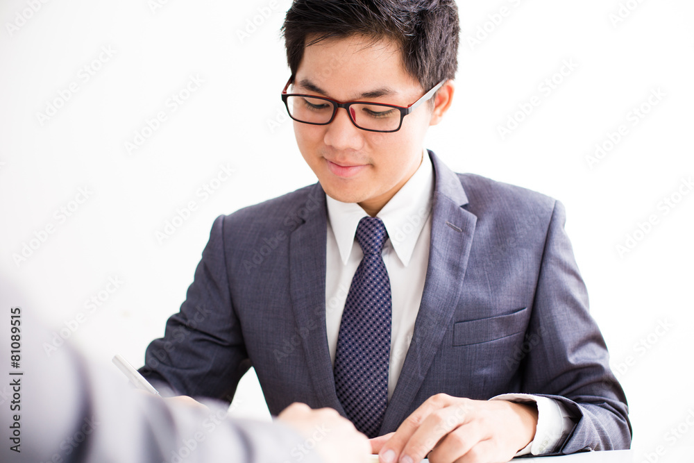 Two businessmen looking at report and having a discussion in off Two businessmen looking at report and having a discussion in off