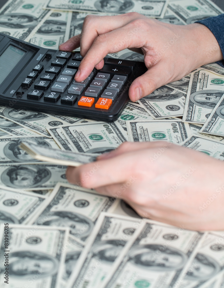 Man's hands with money and calculator Man's hands with money and calculator