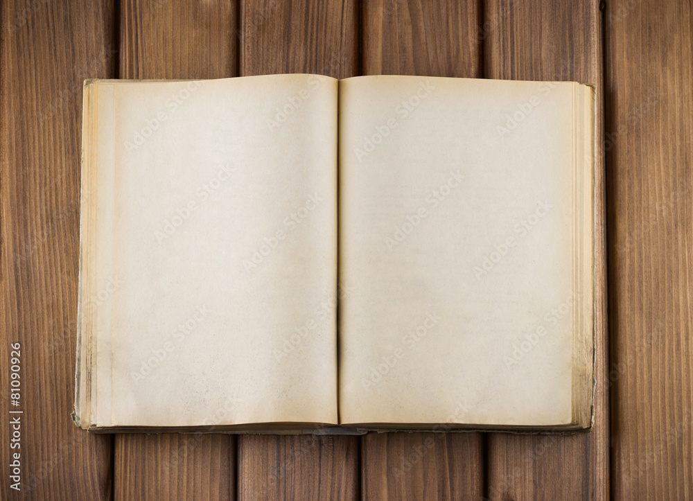 Naklejka premium Top view of blank open old book with grange pages on wooden tabl