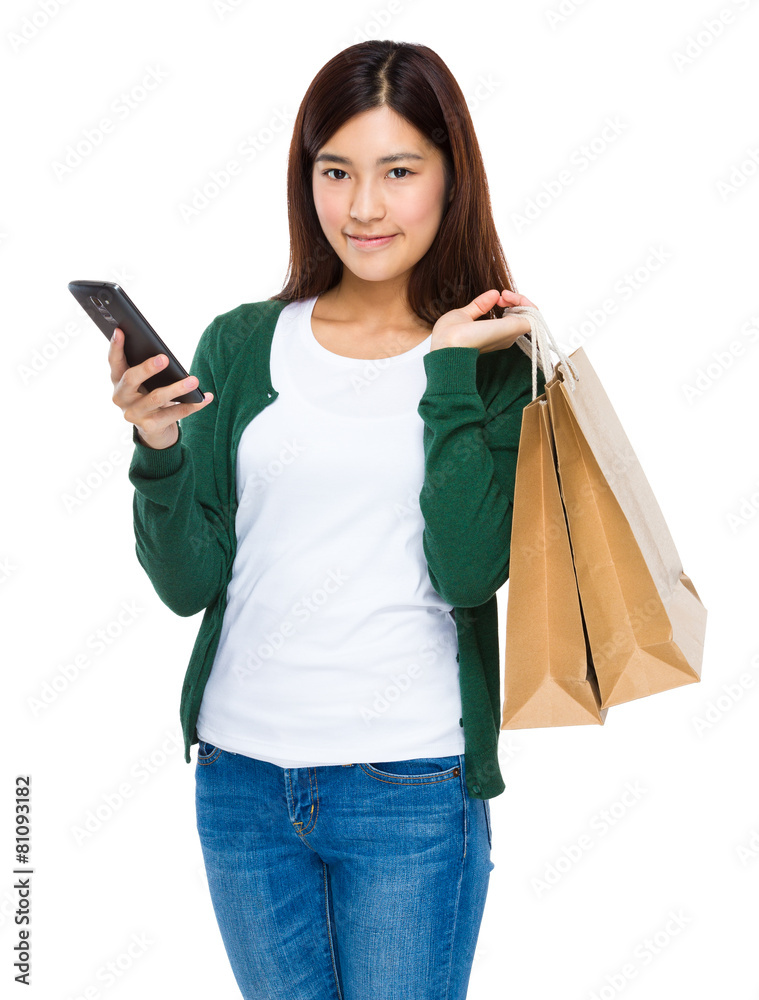 Happy young woman holding shopping bags and mobile phone Happy young woman holding shopping bags and mobile phone