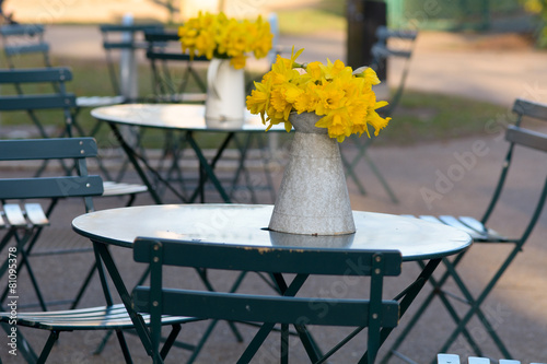 Fototapeta Naklejka Na Ścianę i Meble -  Bunch of daffodils in a vase on a table at a cafe
