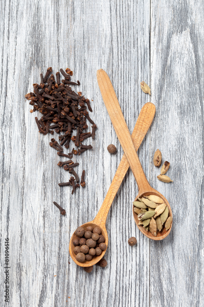 Nutmeg, clove and allspice in old spoon on wooden table Nutmeg, clove and allspice in old spoon on wooden table