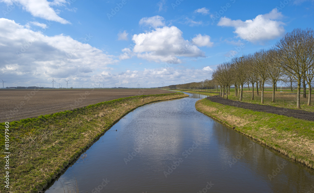 Canal under a blue cloudy sky in spring
