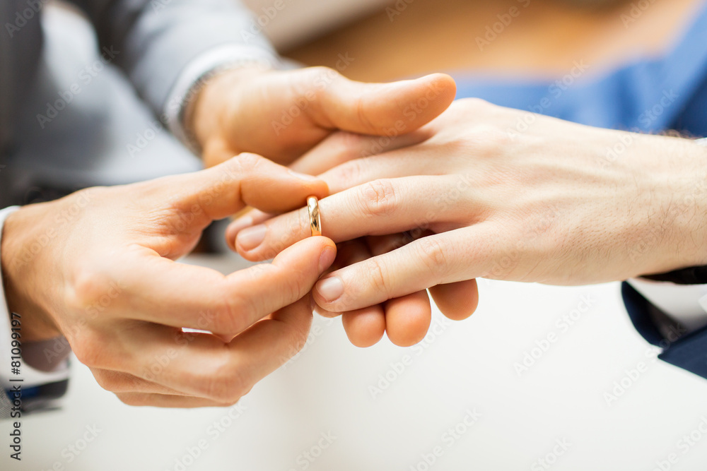 close up of male gay couple hands and wedding ring