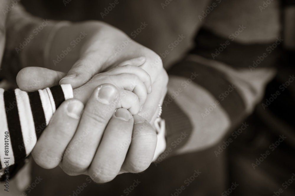 Little hand of the child in the fathers hand