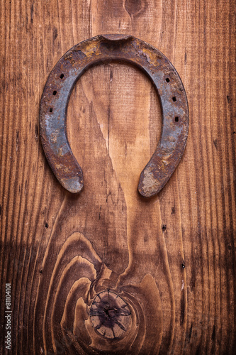 single horseshoe on vintage wooden board close up happy concept