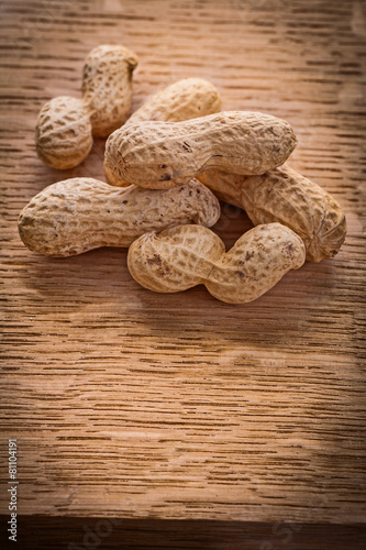 small stack of peanuts on vintage wooden board food and drink co