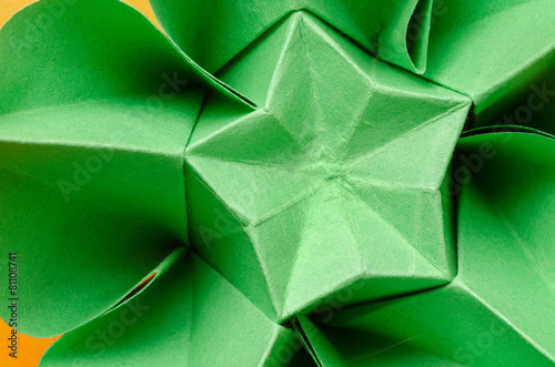 Abstract closeup of a green paper origami flower with star shape