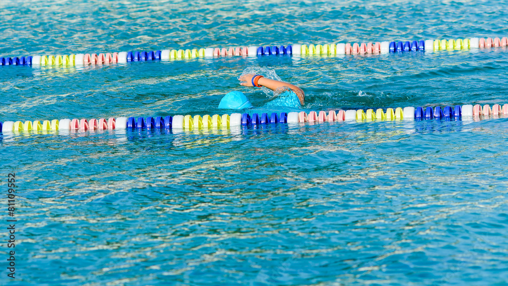 swimmer swimming crawl in blue water and wearing a blue cap