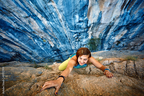 Rock climber climbing up a cliff