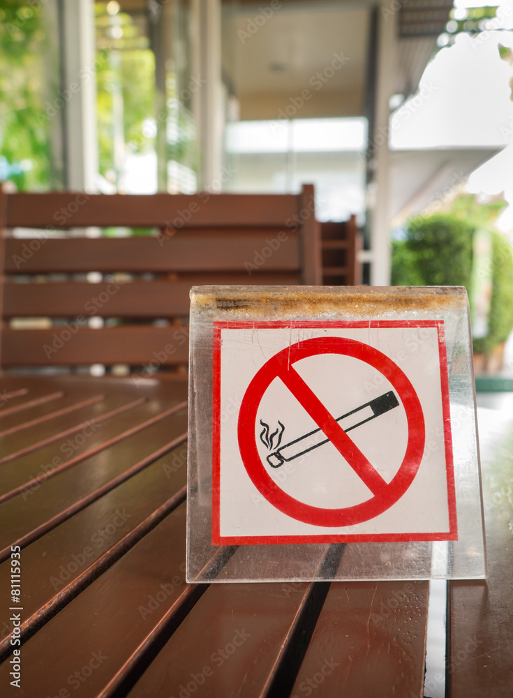 No smoking sign displayed on the wooden table in the public cafe No smoking sign displayed on the wooden table in the public cafe