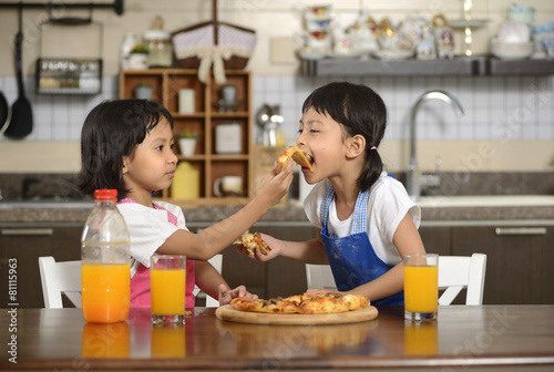 Two Little Girls Eating Pizza