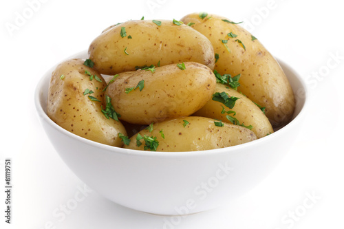 Shiny boiled small potatoes with parsley in bowl.