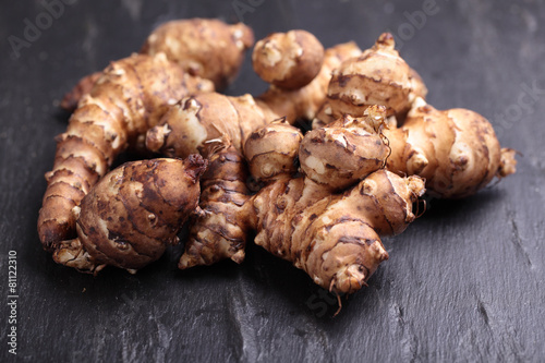 Φωτογραφία Jerusalem artichokes on a slate surface
