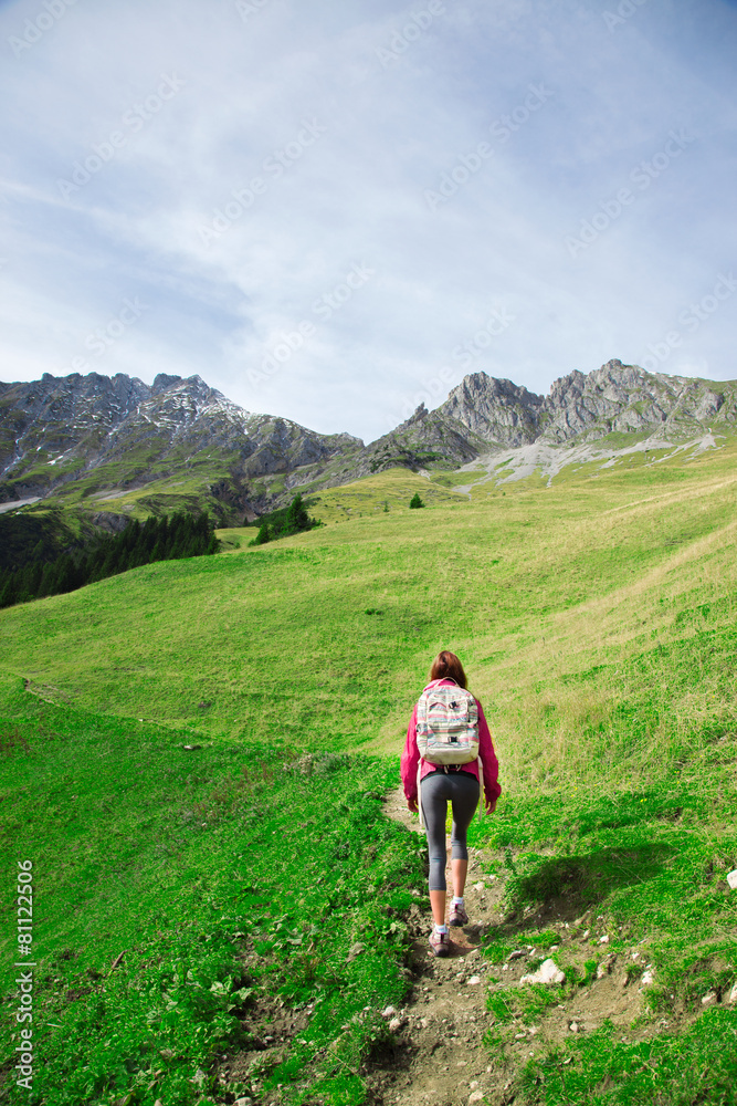 Woman walking all to the top of a mountain