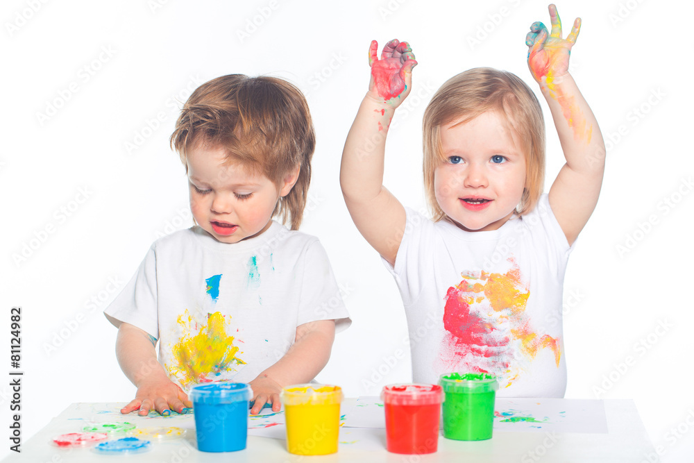 Fototapeta premium Little boy and girl playing with paints