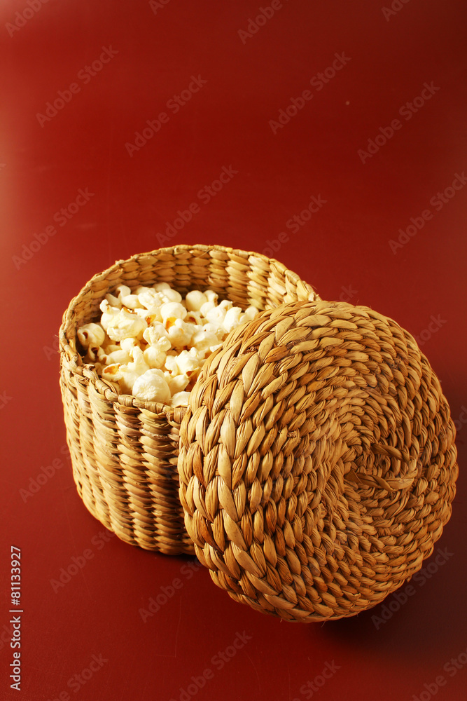 popcorn on red background with basket