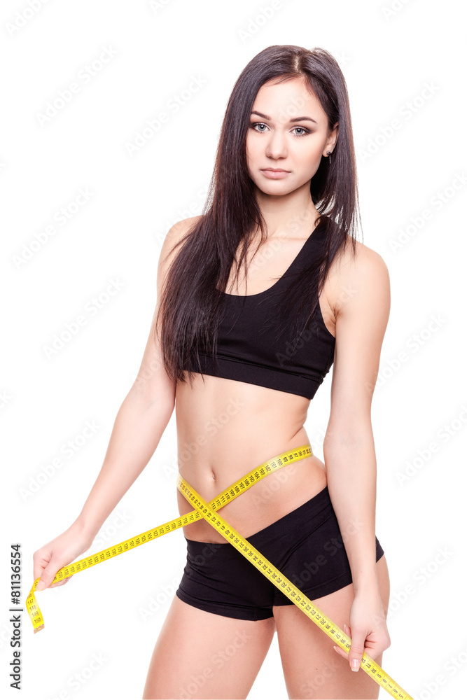Young Woman measuring her waist - Stock Image Young Woman measuring her waist - Stock Image