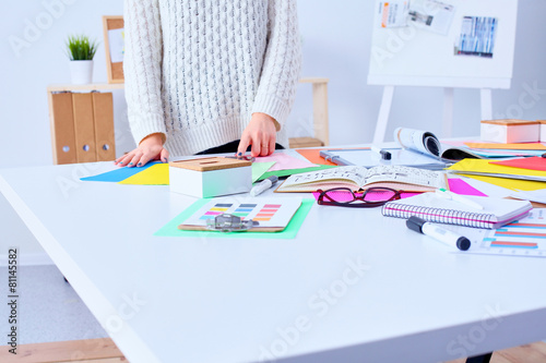 Young female designer standing in office