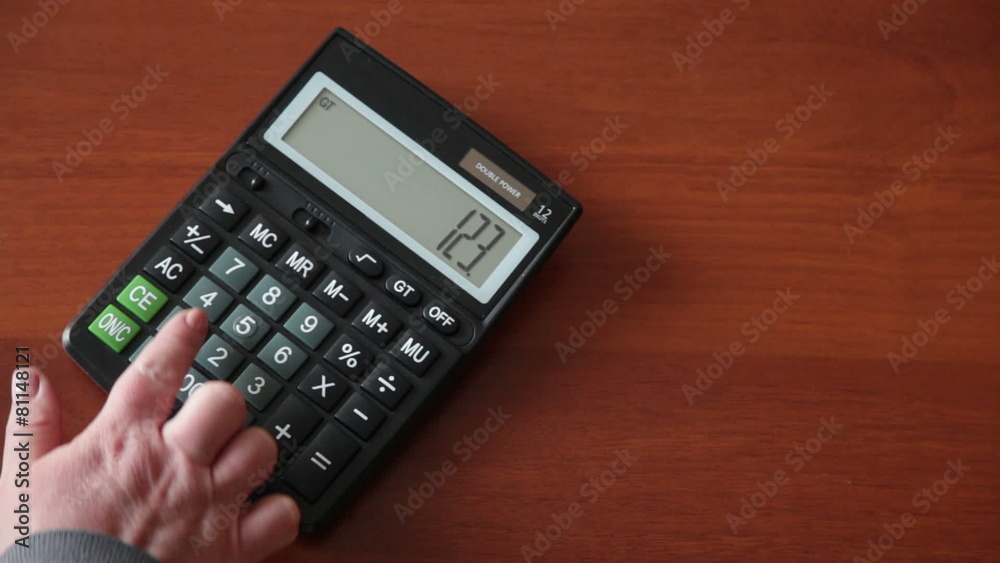 female hand presses the button on the calculator female hand presses the button on the calculator
