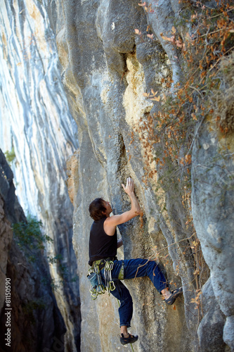 Rock climber climbing up a cliff